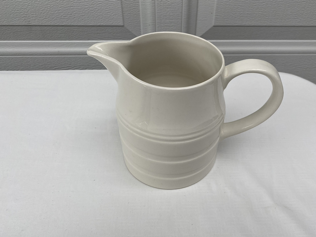 cream ceramic pitcher        
        <figure class=