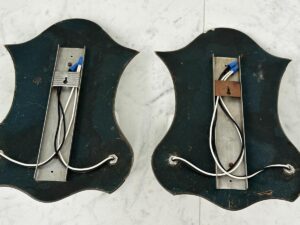 Two Vintage Mirrored Double Arm Sconces with exposed wiring and metal brackets on the back, resting on a white marble surface.