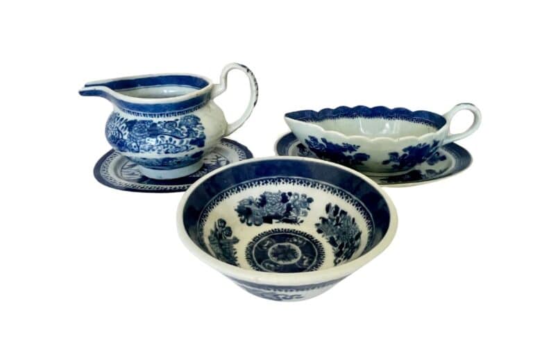 A set of blue and white ceramic dishes featuring floral patterns, including a jug, bowl, and dish, each on a matching saucer.