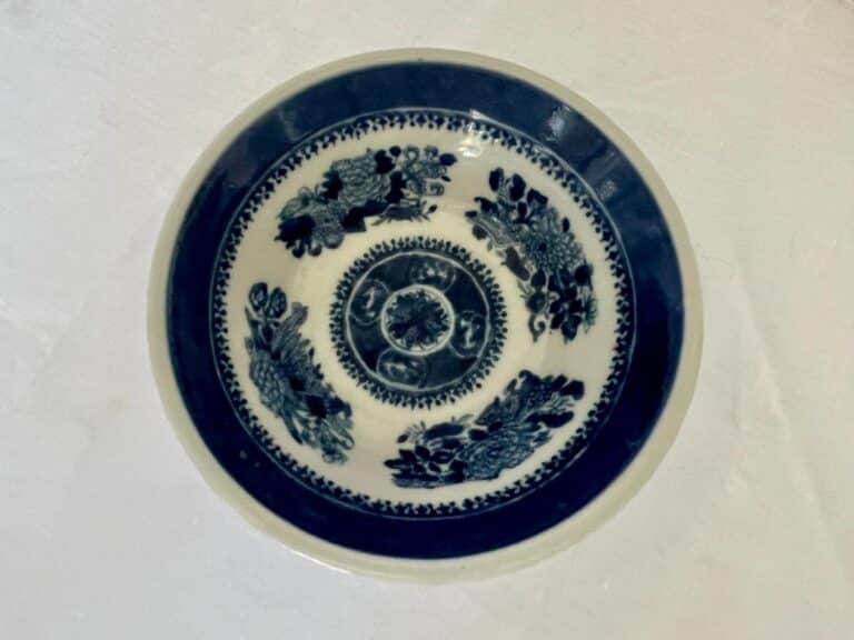 A round white ceramic plate with intricate blue floral and geometric designs on a light background.