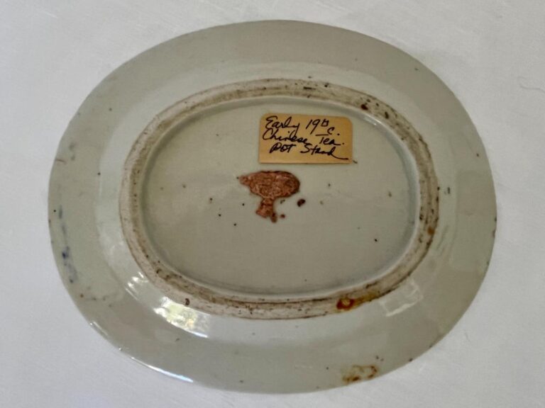 Back of an oval ceramic plate with faded pattern, marked with a small label reading "Early 19th c. Chinese, possibly Stuok.