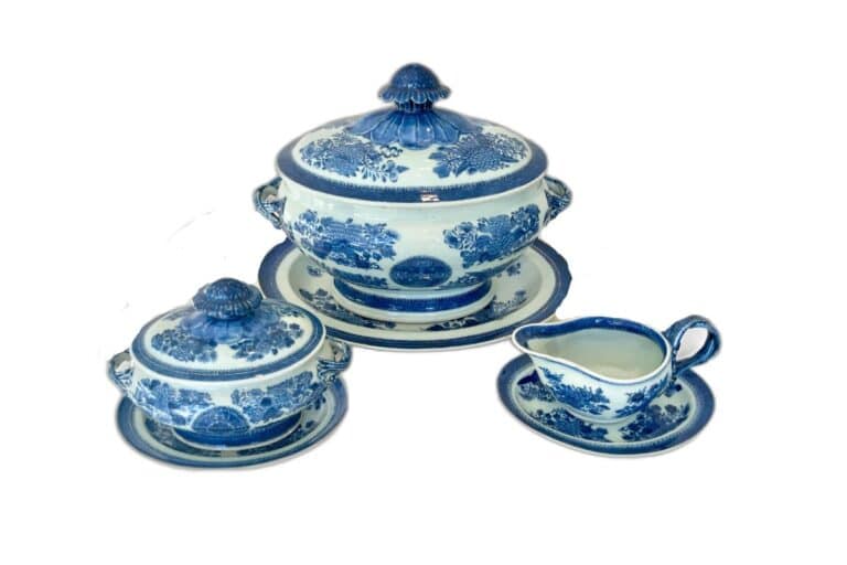 Blue and white porcelain dinnerware set with floral patterns, including two covered bowls on plates and a gravy boat on a saucer.