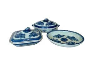 Three blue and white porcelain dishes with floral designs; two are lidded and one is an open serving dish.