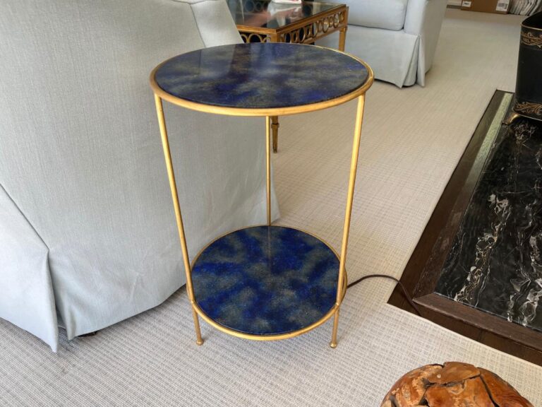 Pair of gold-framed round tables with blue stone surfaces, featuring two tiers, placed on a lightly carpeted floor.