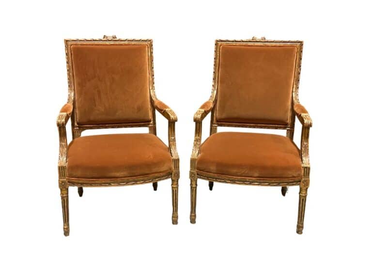 Two matching vintage wooden chairs with ornate carvings and plush brown upholstery.