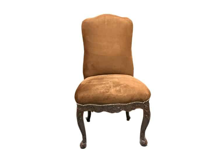 A brown upholstered chair with ornate wooden legs and a high backrest.