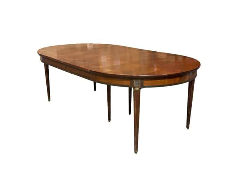 Oval wooden dining table with six slender legs, featuring a polished surface and visible grain patterns.