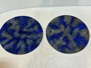 Two round coasters with a blue and gray marbled pattern placed on a white surface.