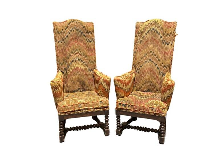 Two ornate high-back chairs with patterned upholstery and dark wooden legs, featuring a zigzag design and intricate carvings.