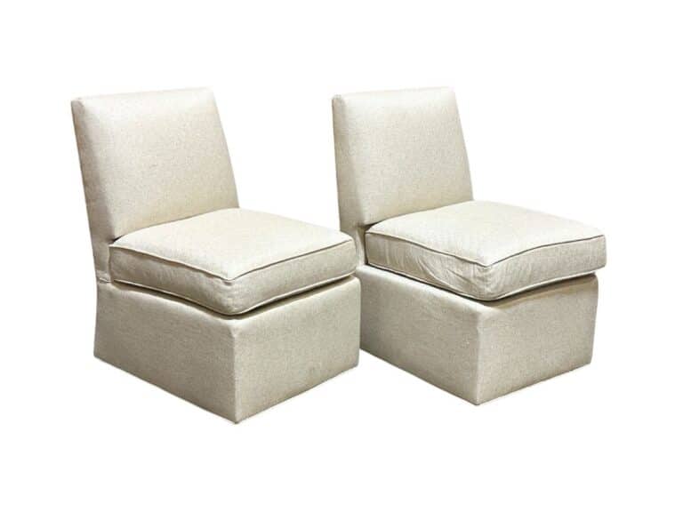 Two beige upholstered armless chairs with cushioned seats and backs, set side by side on a white background.