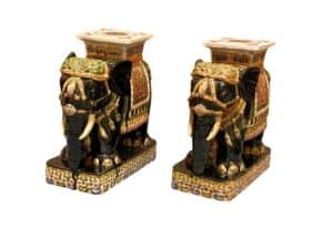 Two ornate ceramic elephant figurines with intricate patterns and flat tops, designed as decorative stands or stools.