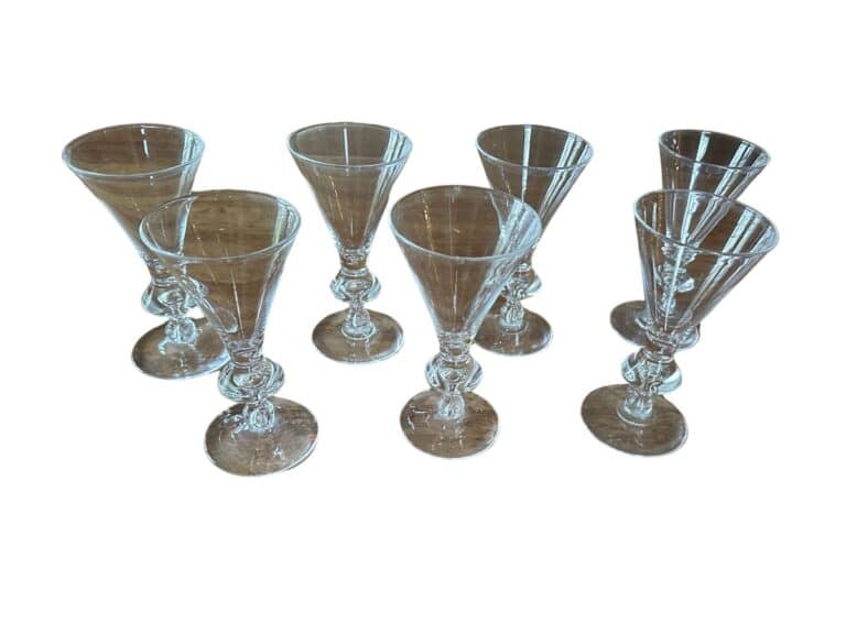 Seven clear crystal wine glasses arranged in a group.