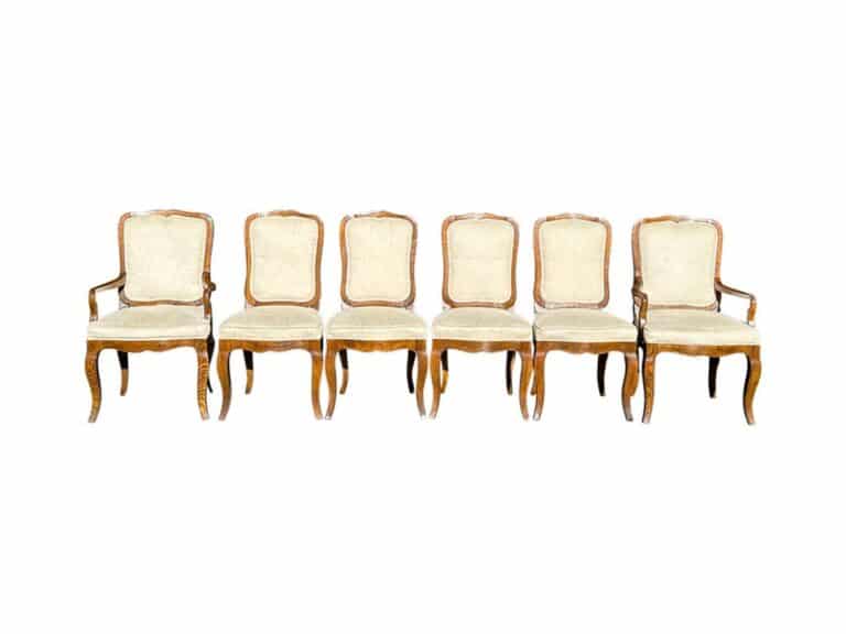 A set of six Baker Milling Road French Provincial dining chairs with vintage wooden frames and beige upholstered seats and backs are arranged in a row.