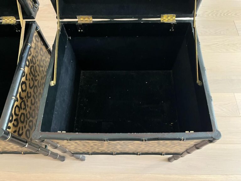 Open storage chest with a leopard print exterior and black interior, placed on a wooden floor.