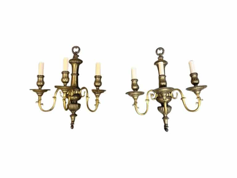 The image shows a pair of classic-style, three-arm brass wall sconces by EF Caldwell, each featuring candle-shaped lights against a white background.