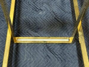 Close-up of a metal frame on a dark, quilted fabric with a zigzag pattern.