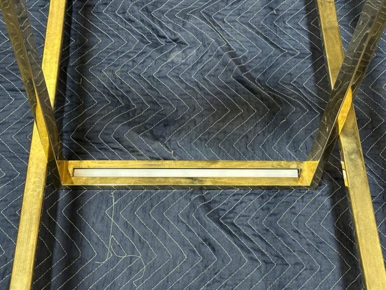 Close-up of a metal frame on a dark, quilted fabric with a zigzag pattern.