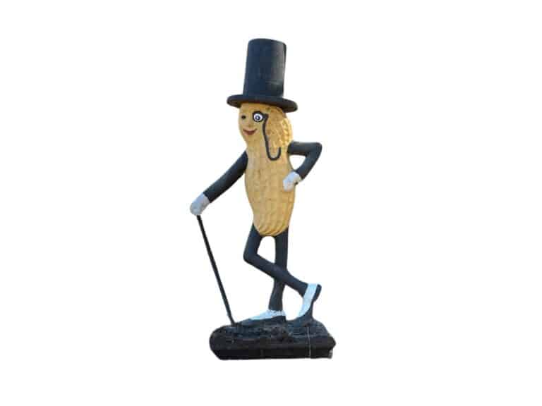 A "Life Size" Mr. Peanut statue made of cast iron, depicting the smiling peanut character in a top hat and monocle, holding a cane and stepping forward with one leg.