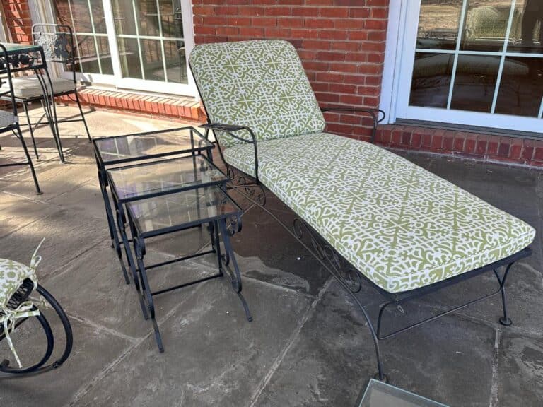 Stone-floored patio featuring a Vintage Wrought Iron Patio Set with green patterned newly upholstered cushioned chaise and nested glass-top tables.