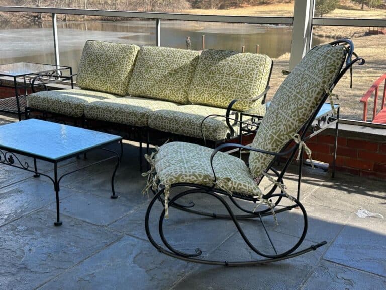 Vintage Wrought Iron Patio Set with newly upholstered green patterned cushions, featuring a sofa, rocking chair, and glass-topped table near a lake.