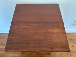 Top view of a Bachelor's Chest of Drawers with visible hinges, placed on a wooden floor.