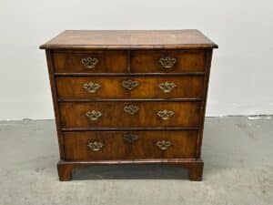 Antique Burl Chest of Drawers featuring five drawers and ornate metal handles set against a plain white background.