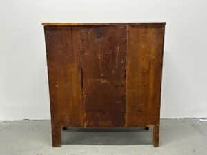A vintage wooden cabinet with a worn finish against a plain background.