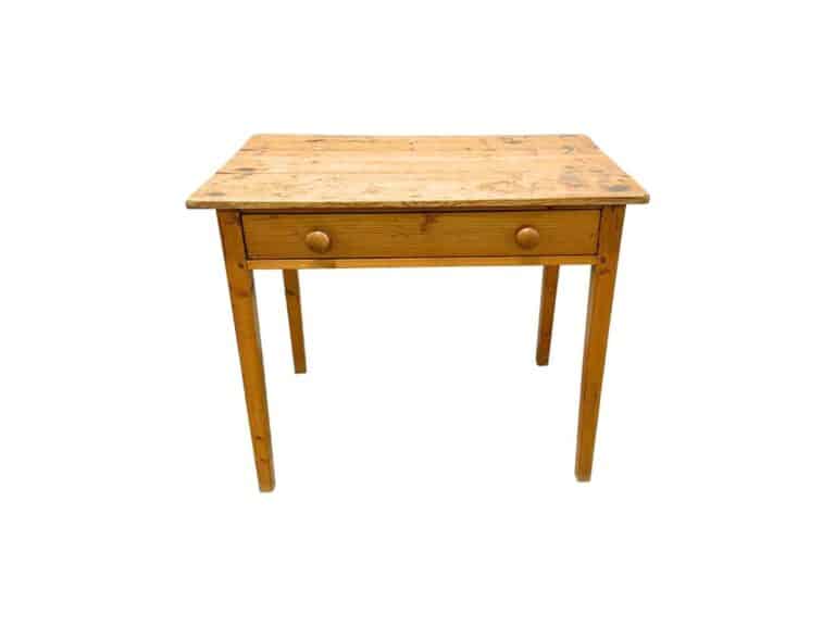 A well-used Antique Pine Writing Table featuring one drawer and round knobs on each side.