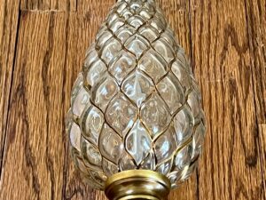 A Vintage Pineapple Crystal & Brass Lamp on wooden flooring.