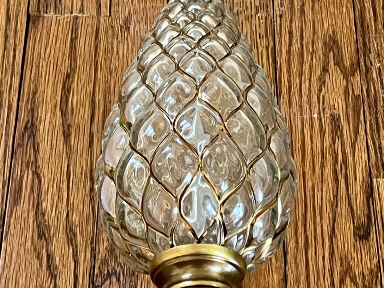 A Vintage Pineapple Crystal & Brass Lamp on wooden flooring.