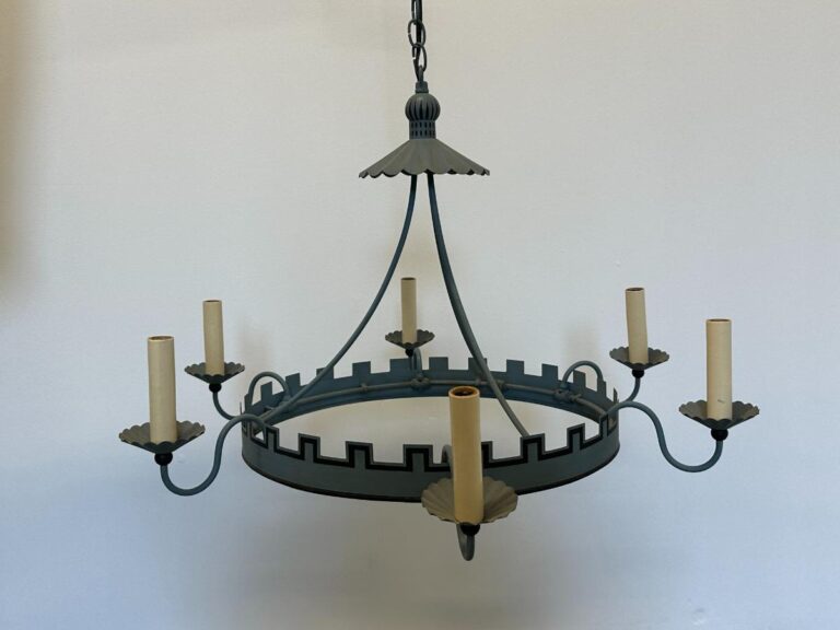 A medieval-style metal chandelier with candle-shaped holders, hanging against a plain background.