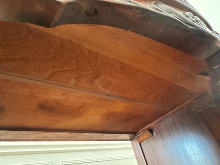 Underneath view of the French Carved Mahogany Vanity Ladies Desk showcasing visible grain patterns and carved details.