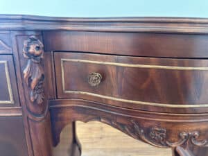 Close-up of the French Carved Mahogany Vanity Ladies Desk featuring ornate wooden drawers with floral carvings and detailed brass handles.