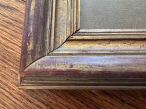 Detail of Passé Temps Des Dames Framed Prints, Set of 2, featuring ornate gold and red wooden corner detailing on a wood surface.