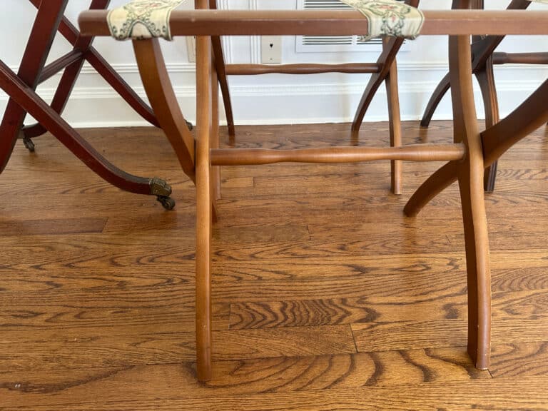 French Carved Mahogany Vanity Ladies Desk with floral fabric straps on a hardwood floor.