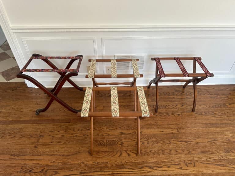 A trio of French Carved Mahogany Vanity Ladies Desks, each adorned with colorful fabric straps, are arrayed on a wooden floor against a white wall.