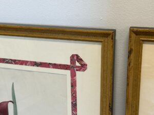 Two artworks from the set "Pierre Joseph Redoute Botanicals, Framed, Set of 6," featuring floral designs in wooden frames, are displayed on a white wall.
