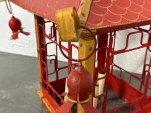 Close-up of a decorative red lantern with gold accents and hanging ornaments on a table.