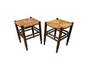 The Rush Stools, Pair are two wooden stools with woven seats, featuring a simple and rustic design.