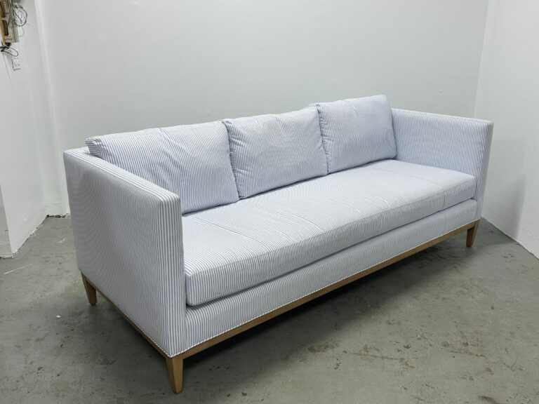 The Serena & Lily Barton Sofa features light blue stripes and wooden legs, sitting elegantly in a white room.