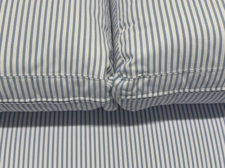 Close-up of two Serena & Lily Barton Sofa blue and white striped cushions set against a matching striped background.