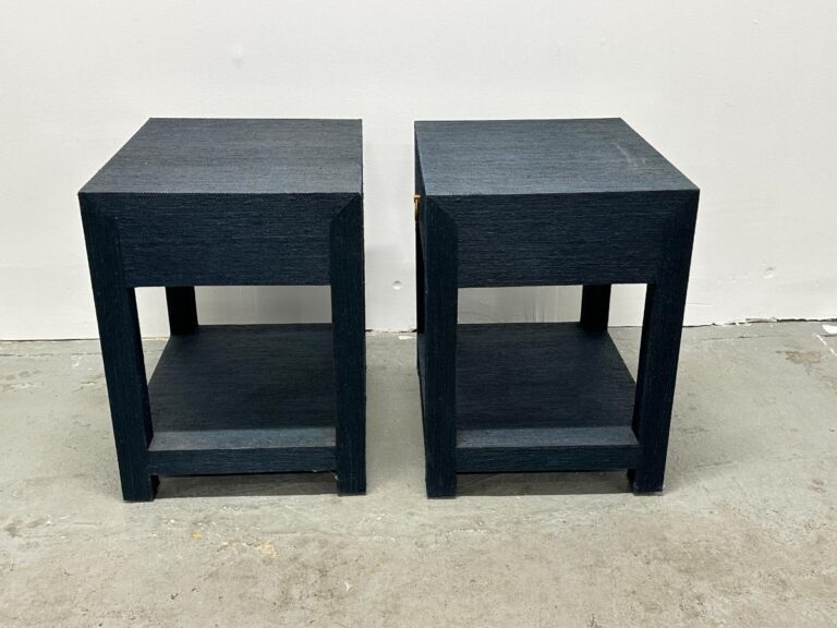 Two Serena & Lily Driftway dark blue wooden square nightstands with lower shelves sit on a gray concrete floor.