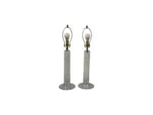 A pair of Simon Pearce Glass Column Lamps with transparent glass and brass fittings, complete with light bulbs and circular bases.