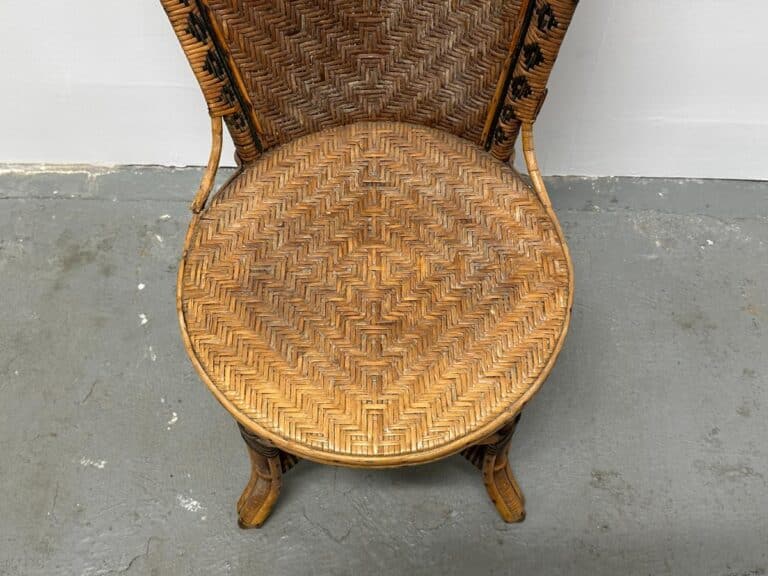 Woven wicker chair with a circular seat and backrest on a gray concrete floor.