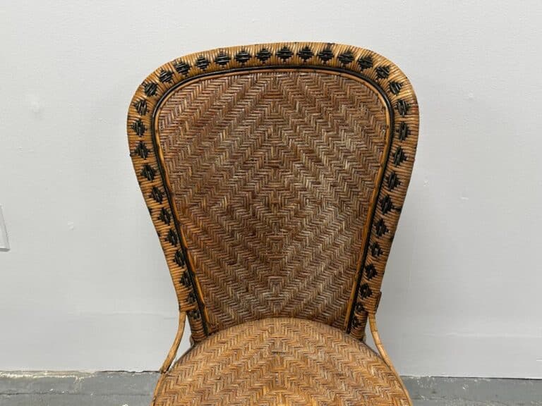 Wicker chair with a patterned border against a plain white wall.