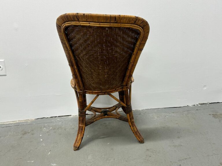 Back view of a wooden wicker chair against a white wall and gray floor.