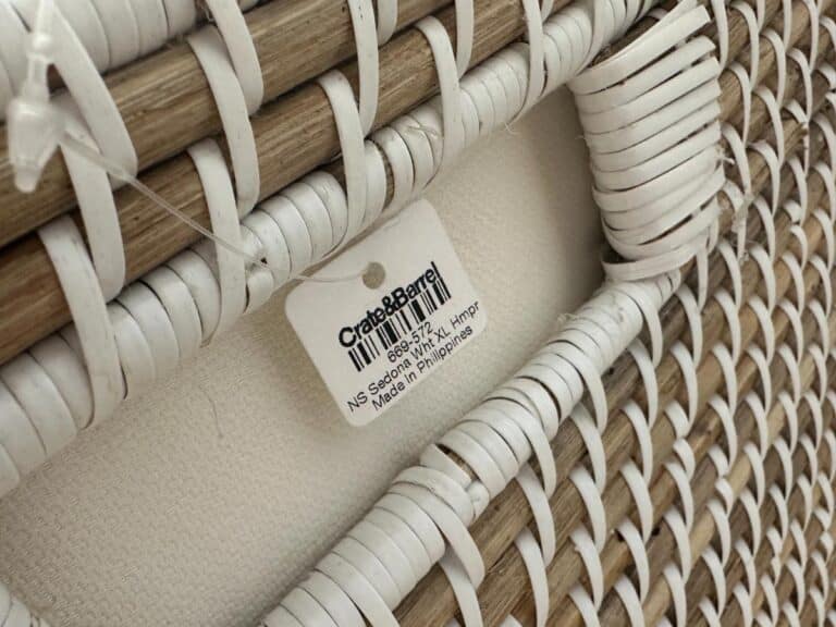 Close-up of a woven frame with a Crate & Barrel tag attached, showing product details and barcode.