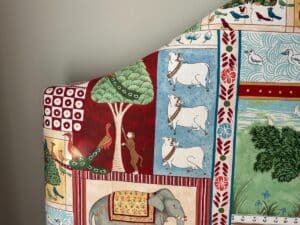 Colorful headboard with patterned birds, cows, peacock, elephant, tree, and decorative elements in bright shades.