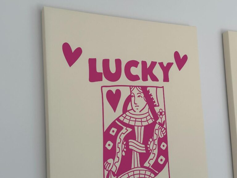 Canvas with a pink queen of hearts card, the word "LUCKY," and two heart symbols above it.