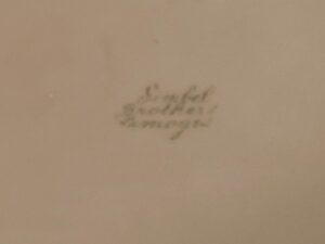 Small, handwritten text on a beige background, difficult to read due to blurriness.